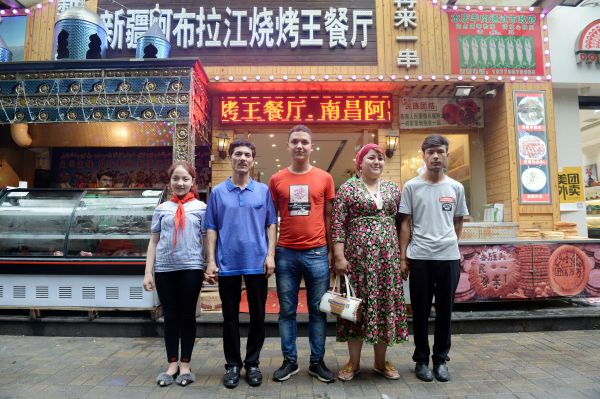 阿卜杜拉一家人在餐厅前合影。（6月21日摄）