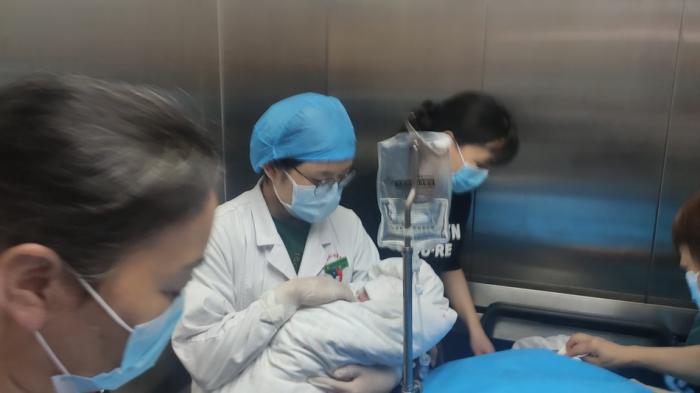 湖北省妇幼保健院妇产科大楼，医护人员抱着彭银华的新生女儿。 澎湃新闻记者 郑朝渊 图